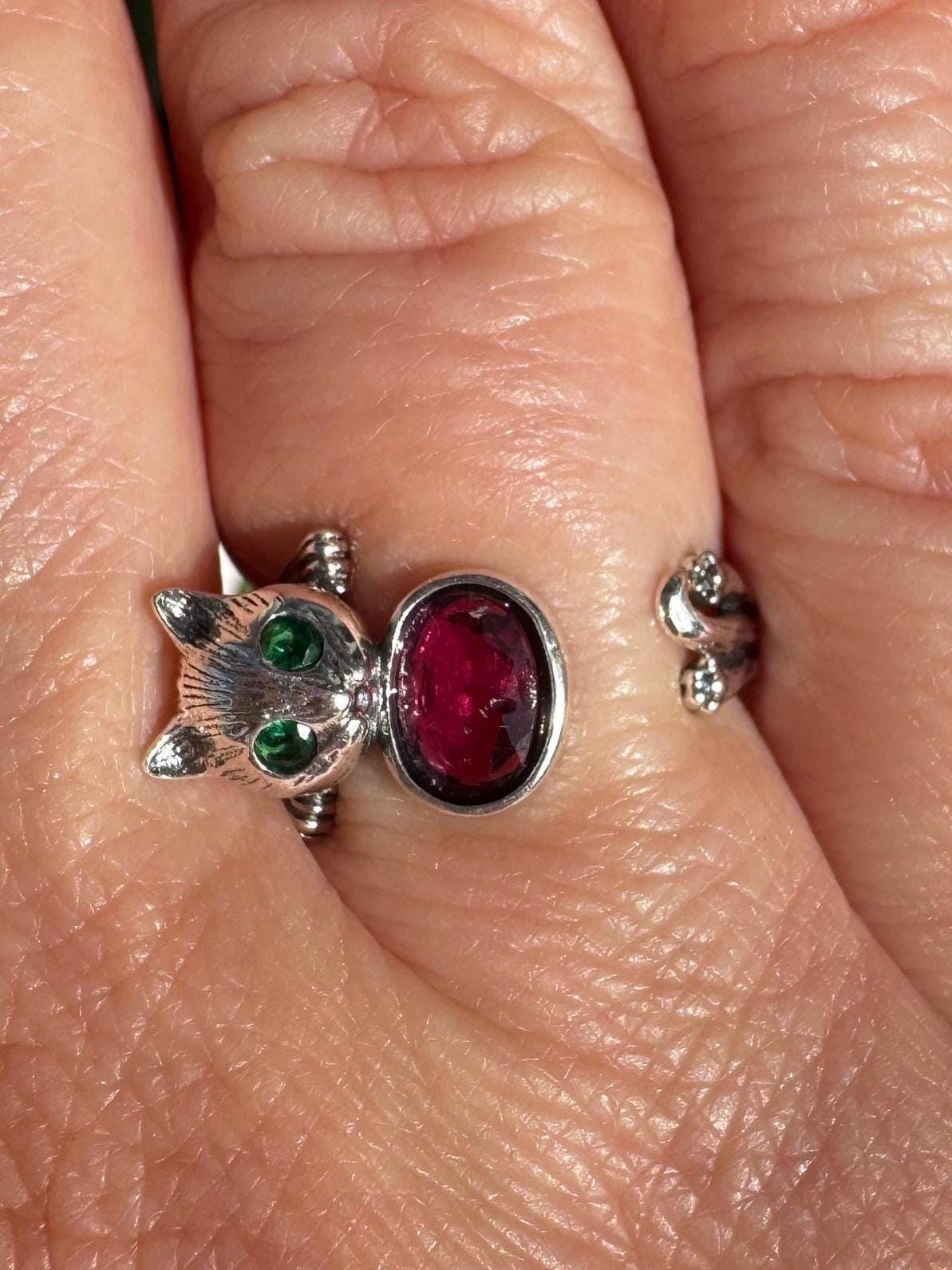 A sterling silver cat ring with a pink tourmaline gemstone, size 6.5 and adjustable, combines whimsical style with the charm of crystal healing jewelry.